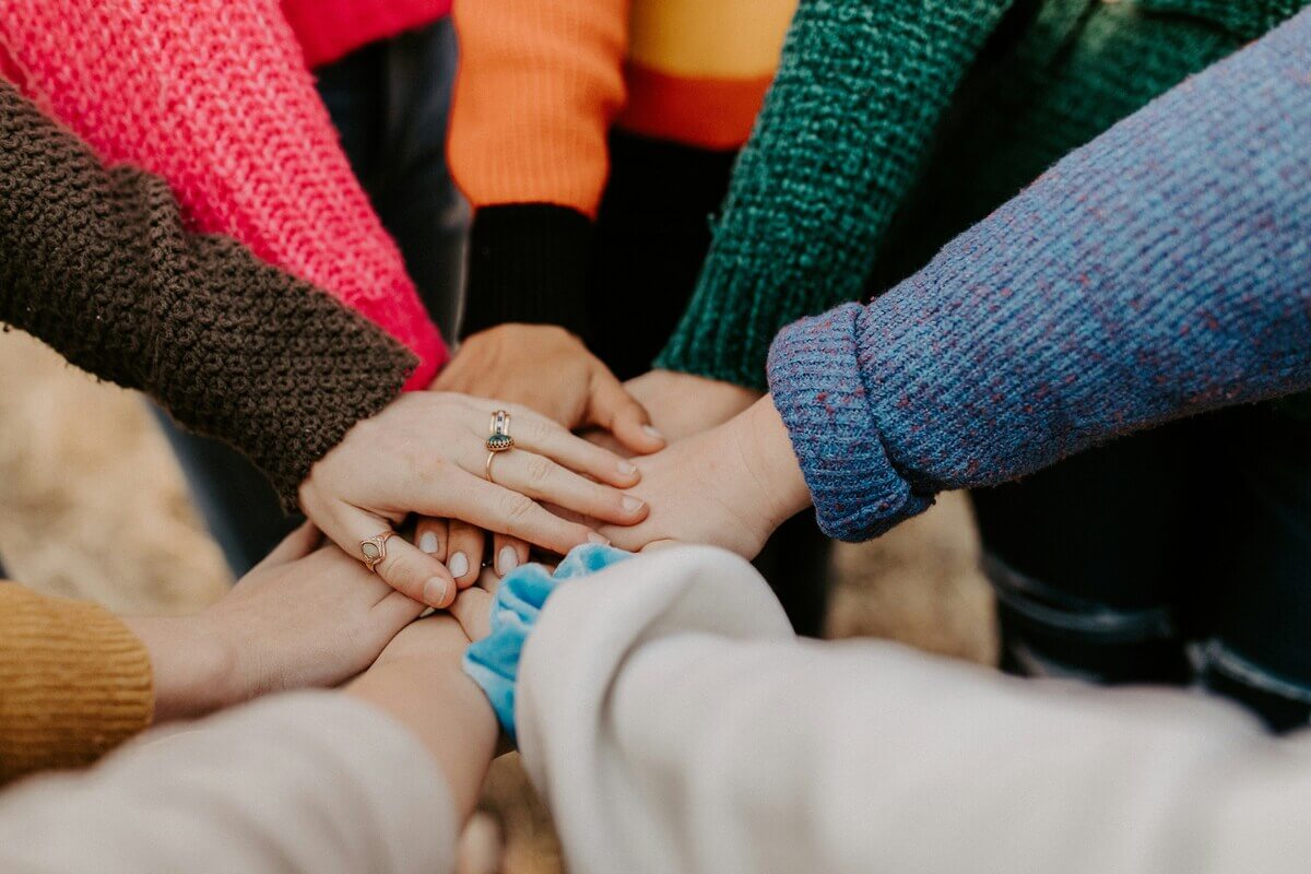 Hände übereinander – Gemeinschaft und Zusammenhalt in Wohnprojekten