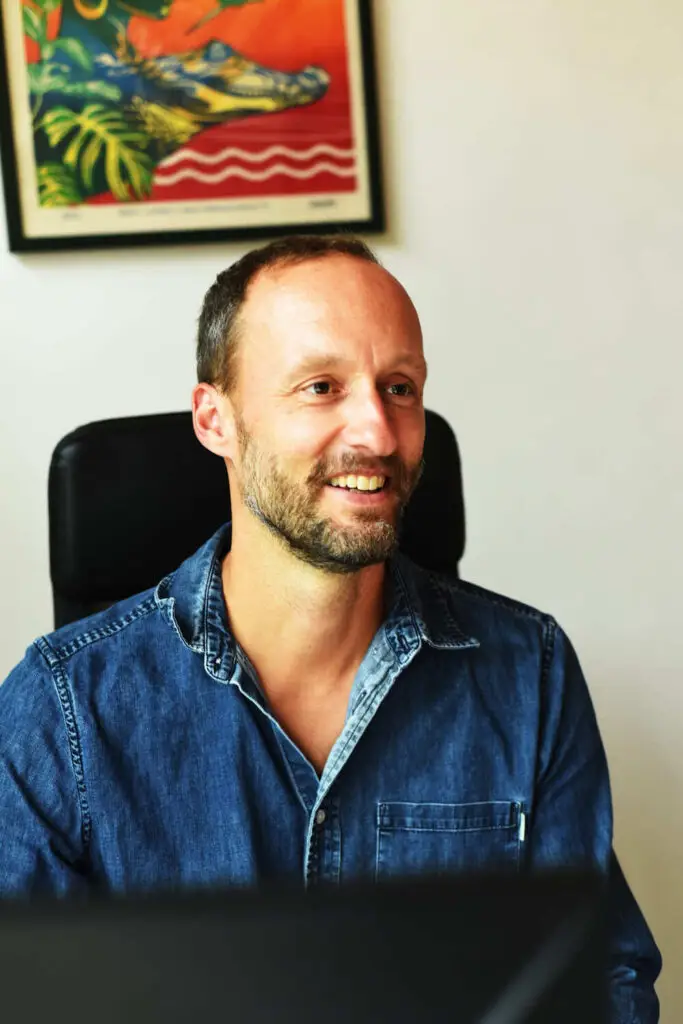 Erik Pfauth sitzt am Schreibtisch und arbeitet als Projektsteuerer